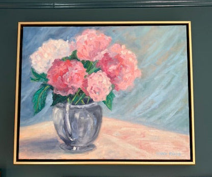 Framed painting of pink flowers and a silver vase on a dark green wall.